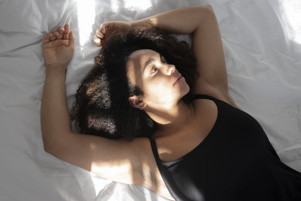 Pode dormir de maquiagem? Descubra os cuidados essenciais para sua pele moça deitada em uma cama